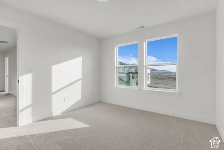 Spacious bedroom with large windows featuring beautiful views.
