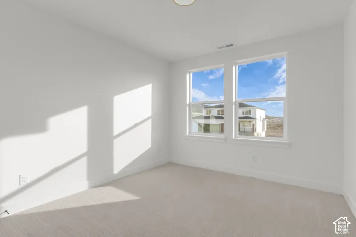 Spacious bedroom with large windows featuring beautiful views.