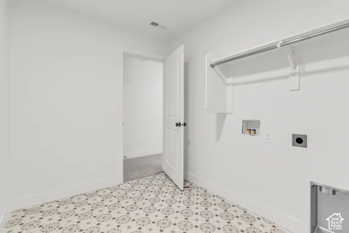 Spacious laundry room featuring patterned floor tiles.
