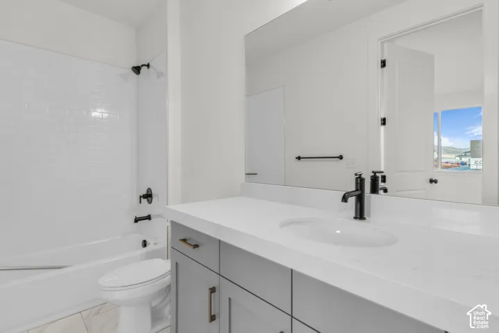 Main floor guest suite bathroom, with white subway tile shower surround and matte black fixtures with soft dove grey cabinetry.