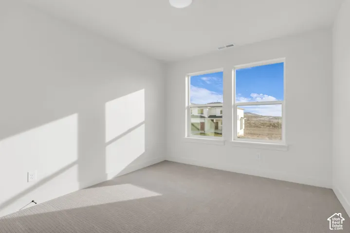 Spacious bedroom with large windows featuring beautiful views.