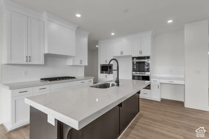 Beautiful full-height cabinetry, with white Quartz countertops, upgraded gourmet appliances with built-in double ovens and a kitchen island with an undermount large single bowl sink and upgraded faucet.