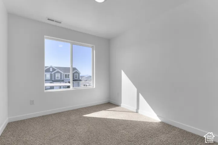 Recessed ceiling lighting, a large window, neutral wall color, and carpeted flooring
