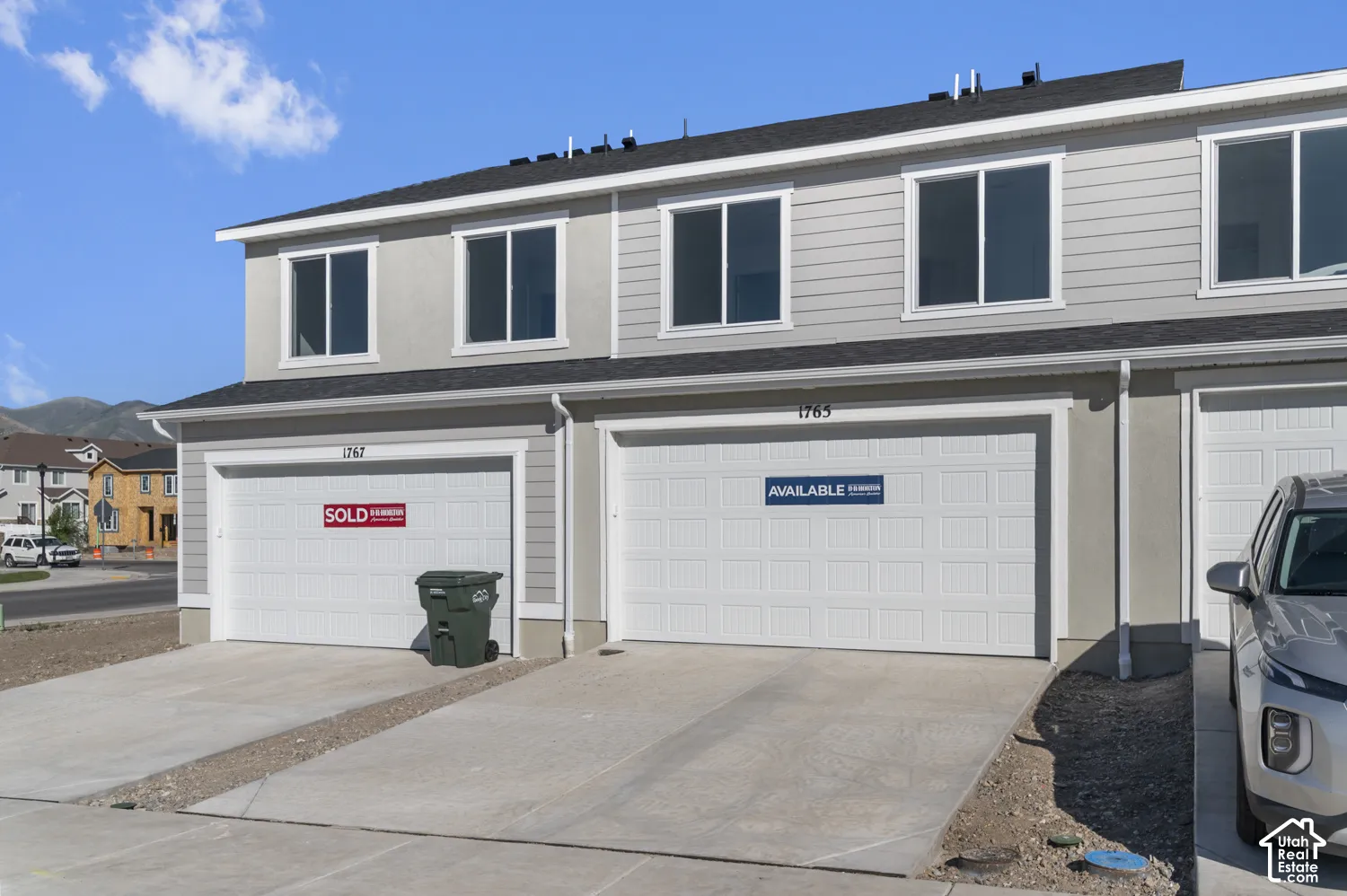 Two-story townhome with light gray siding and white trim