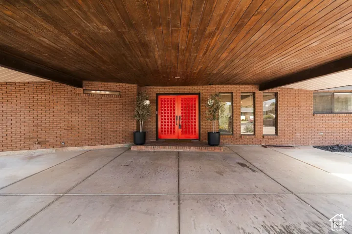 Brick exterior featuring an eye-catching red double door with decorative detailing