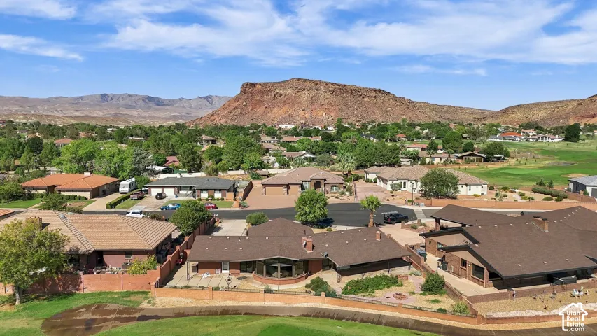 Expansive neighborhood with diverse residential architecture and integrated golf course landscaping, featuring a prominent mountainous backdrop