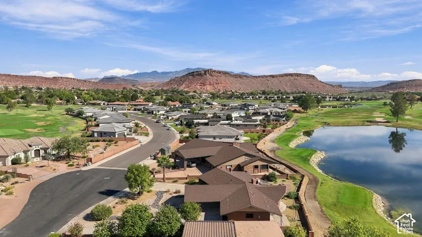 Residential properties with golf course frontage, water feature, and mountainous backdrop