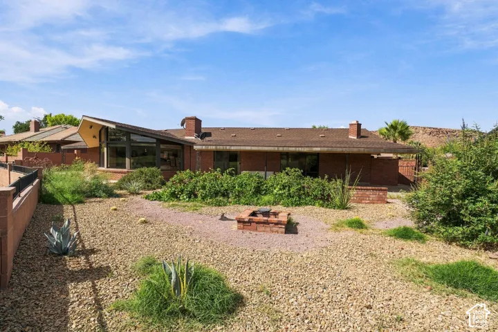 Brick exterior with a peaked roofline, expansive windows, and an outdoor fire pit