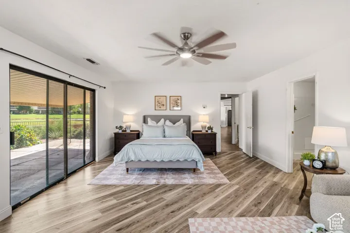 Spacious room with wood-finish flooring, a contemporary ceiling fan, and sliding glass doors