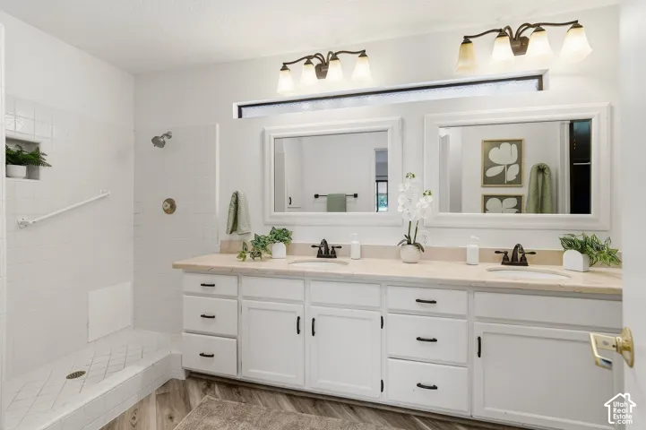 Dual vanity with integrated sinks, white cabinetry, and bronze-finish hardware