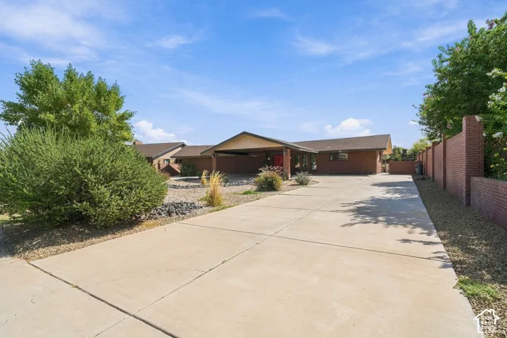 Brick exterior with a covered entryway, attached carport, and a concrete driveway