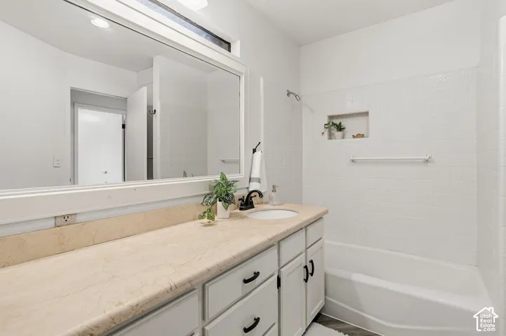White cabinetry with black hardware, integrated sink, and light-toned countertop