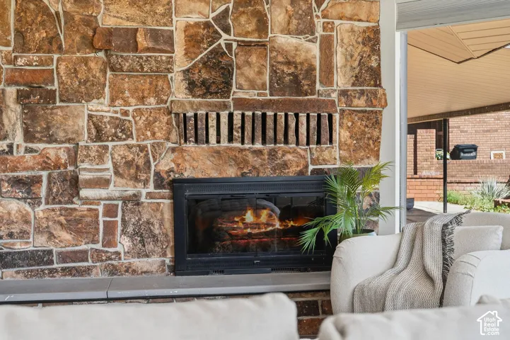 Stone-clad fireplace with a dark-framed insert and a stone hearth