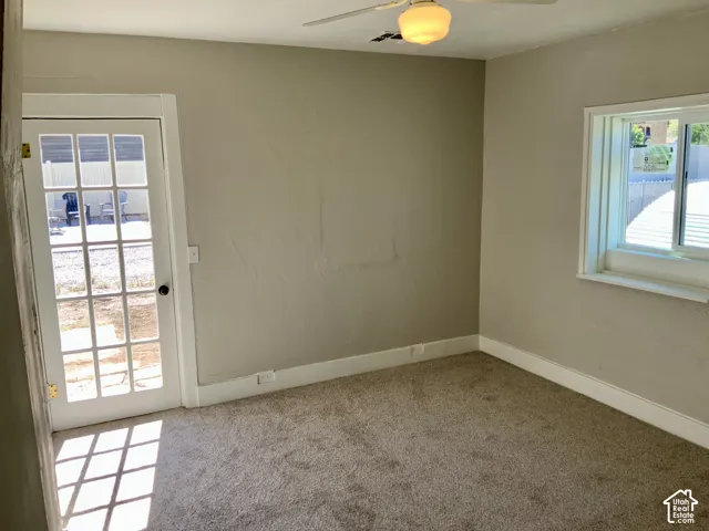 Carpeted flooring, neutral wall tones, white trim, white-framed window, and a ceiling fan with integrated lighting