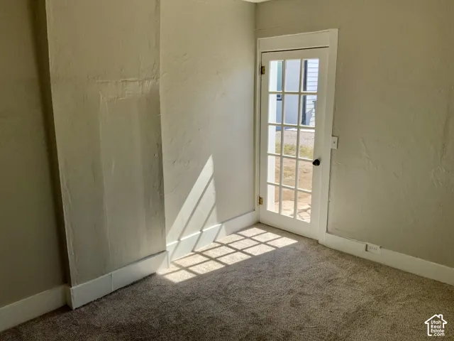 Bright corner room with abundant natural light from French doors and windows