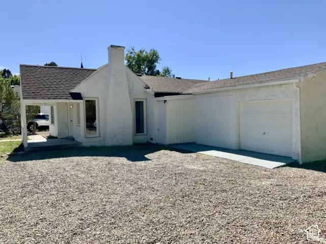 Stucco exterior with a peaked roof, covered front entrance, and an attached single-car garage