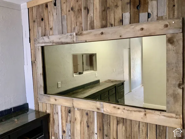 Reclaimed wood-paneled wall with a large, framed mirror