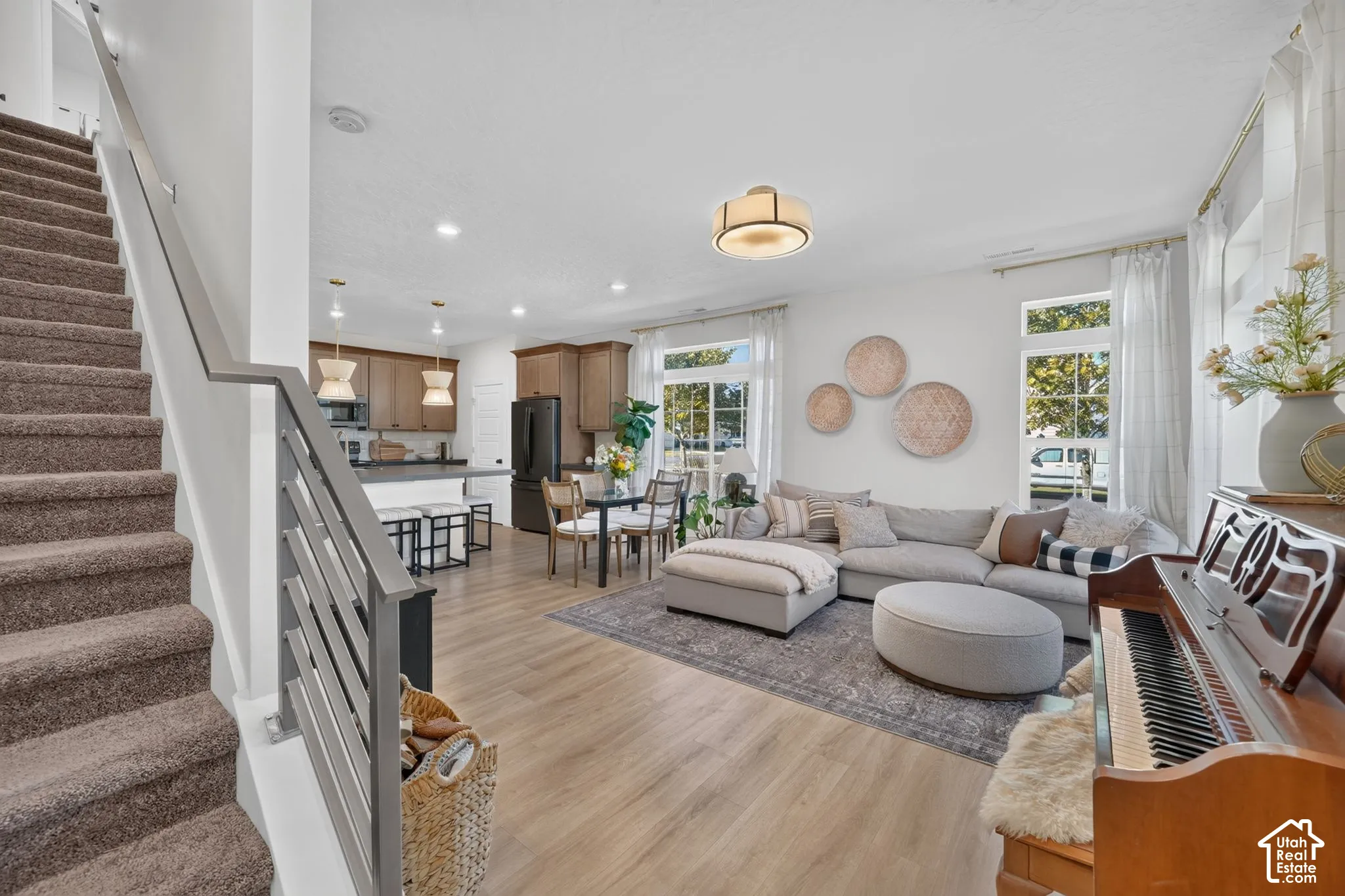 Open concept living space with wood-finish flooring, recessed lighting, and large windows