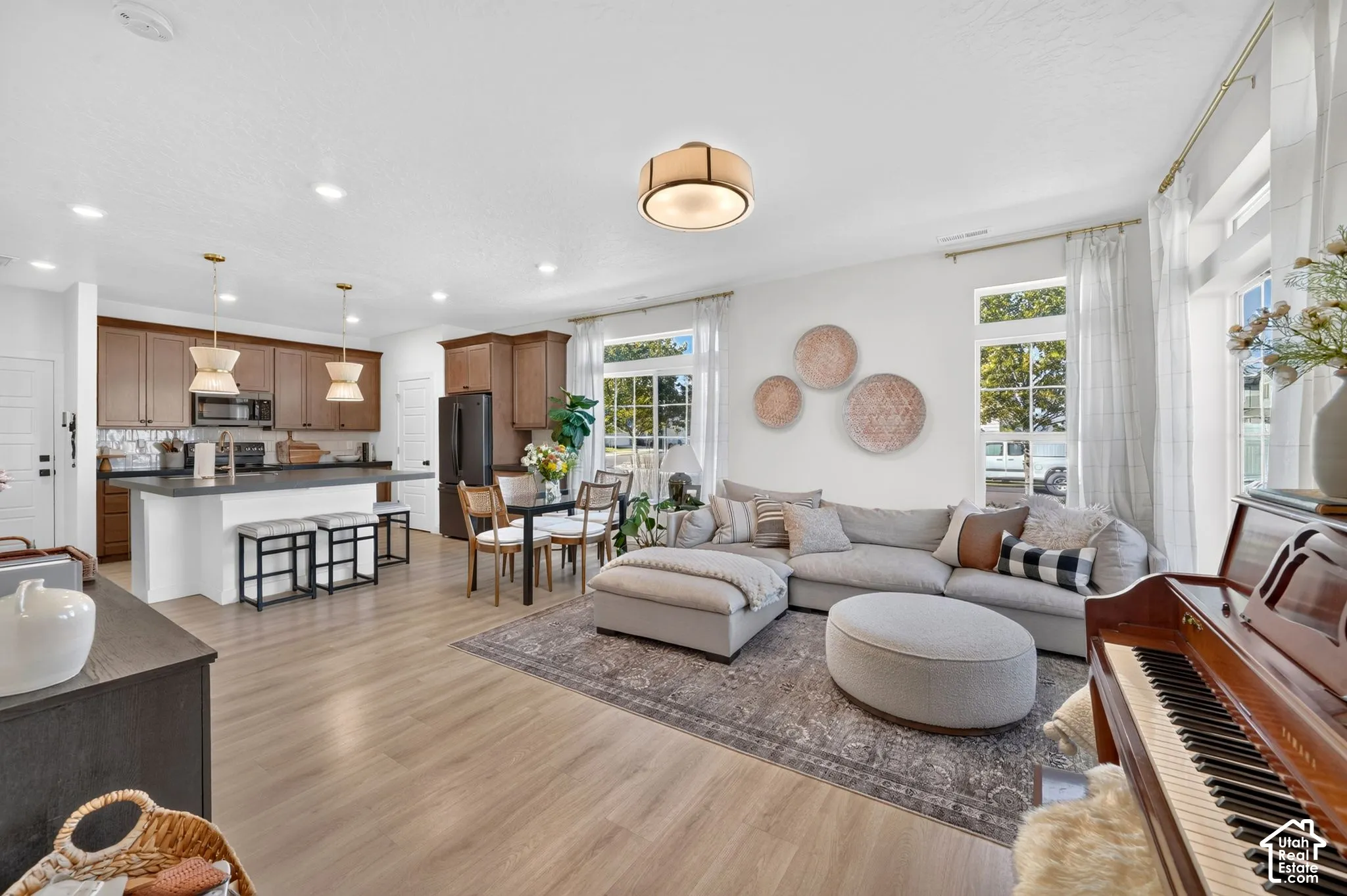 Open-concept living space featuring wood-finish flooring, recessed lighting, and large windows