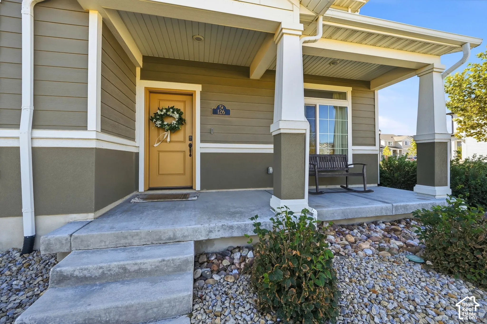 Covered front porch with concrete steps, siding exterior, and a sliding glass door