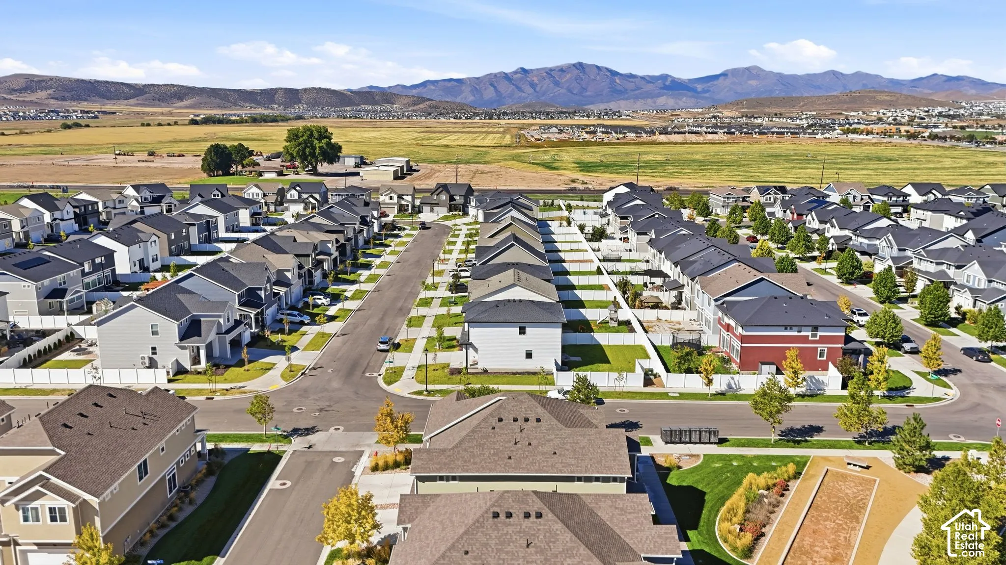 Residential community with varied architectural styles, manicured green spaces, and mountain scenery