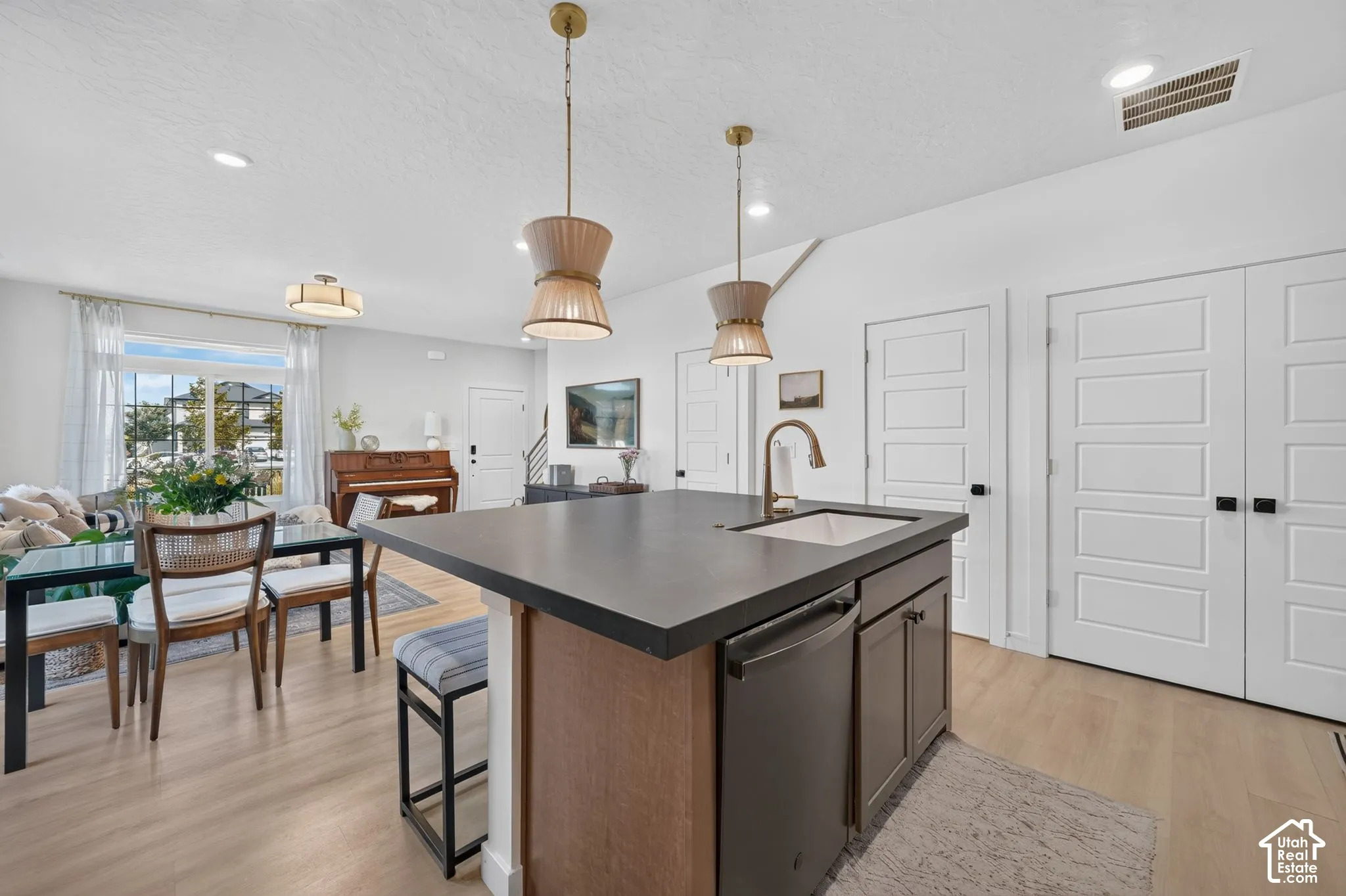 Central kitchen island with an integrated sink and dark countertop