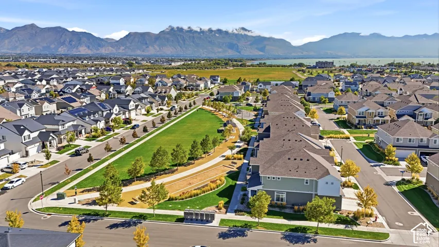 Residential neighborhood featuring a central green space, paved streets, and mountain backdrop