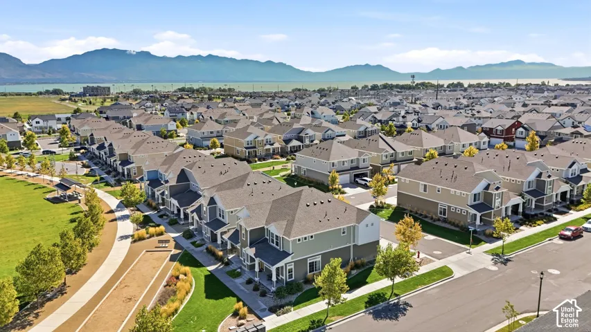 Residential neighborhood featuring a community park with walking paths, mature landscaping, and mountain scenery