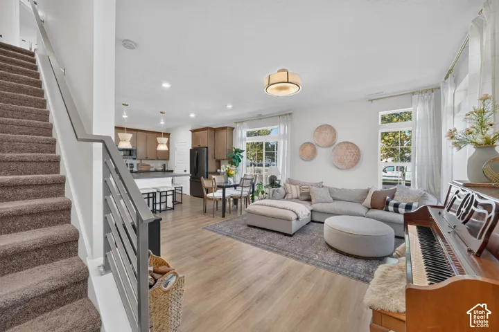 Open concept living space with wood-finish flooring, recessed lighting, and large windows