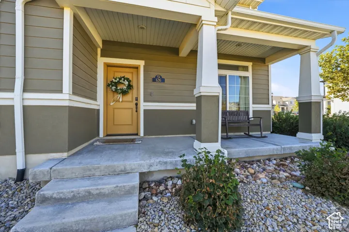 Covered front porch with concrete steps, siding exterior, and a sliding glass door