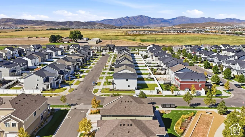 Residential community with varied architectural styles, manicured green spaces, and mountain scenery
