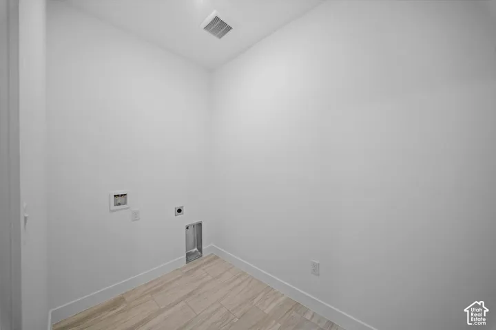Laundry utility connections with tile flooring and a ceiling-mounted light fixture