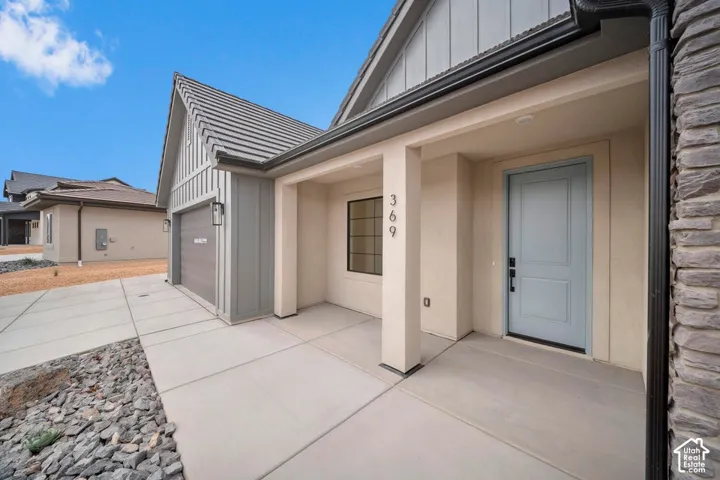 Covered entry with stone veneer accent and light-toned stucco exterior