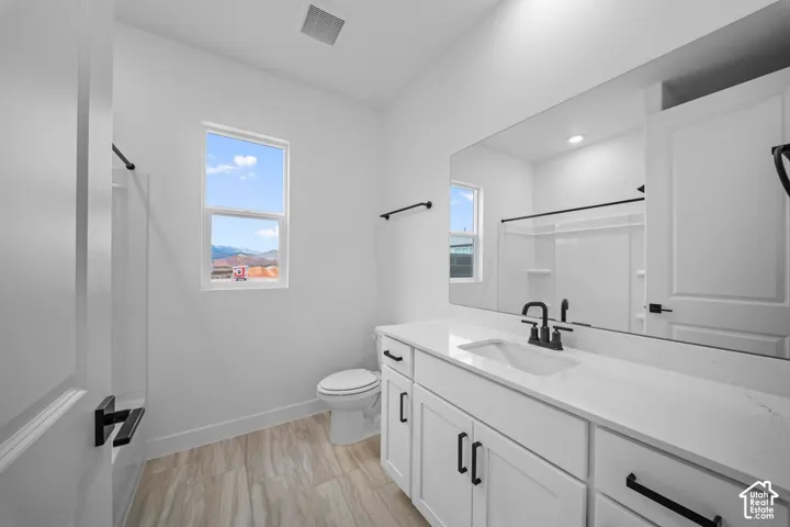 White vanity with integrated sink, stone-finish countertop, and black fixtures