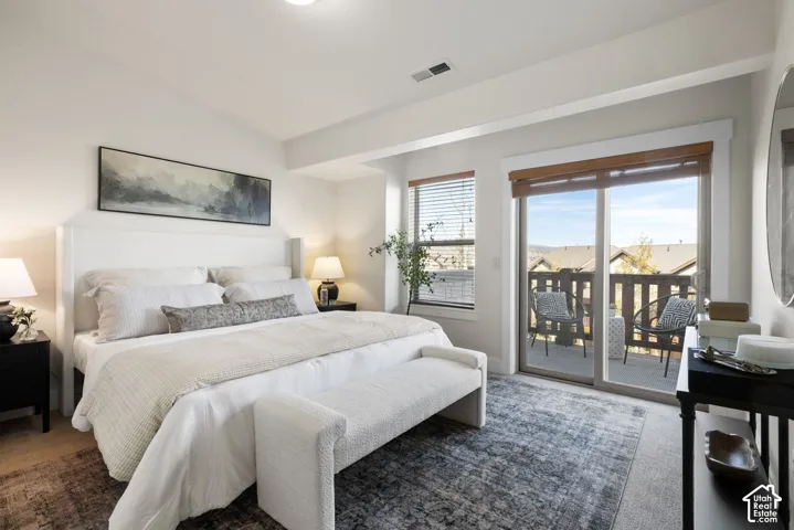 Vaulted ceiling, recessed lighting, sliding glass door to a private balcony, wood-finish window blinds, and wood-finish flooring