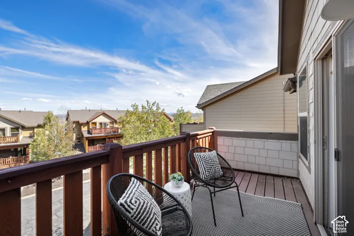 Private balcony featuring wood-finish decking and a wooden railing