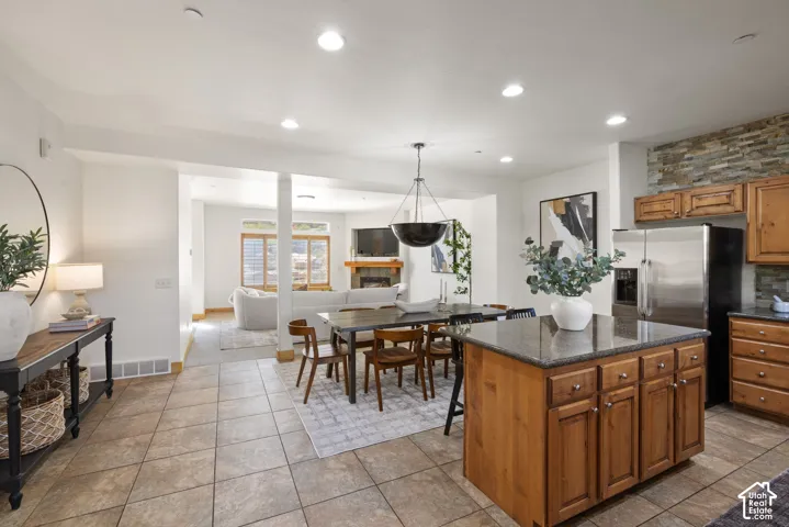 Kitchen island with a stone countertop and wood cabinetry