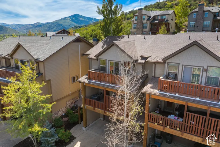 Multi-level dwelling with multiple balconies featuring wood railings and mountain scenery