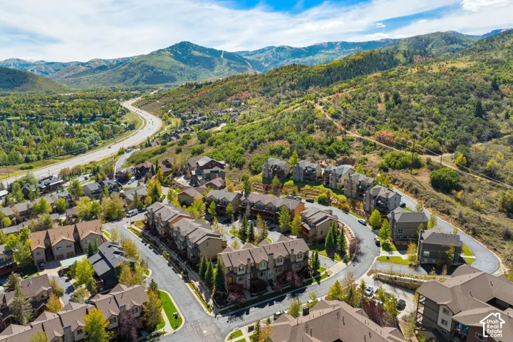 Residential community with a paved road system, surrounded by lush green hills and distant mountains