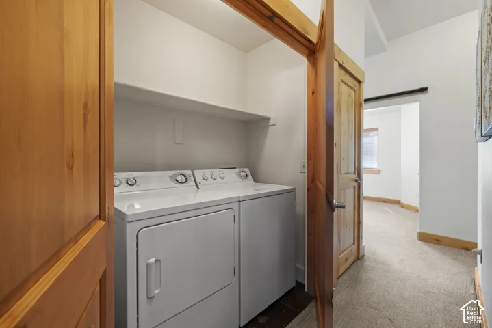 Laundry closet with a built-in shelf and wood-finish flooring