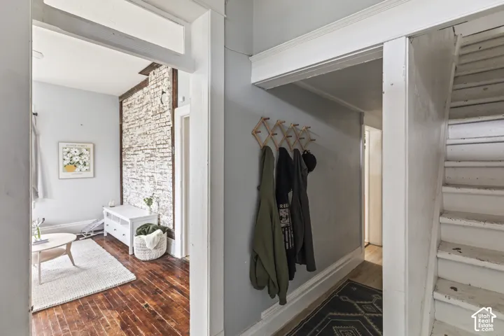 Exposed brick wall detail, painted wood flooring, and painted interior stairs