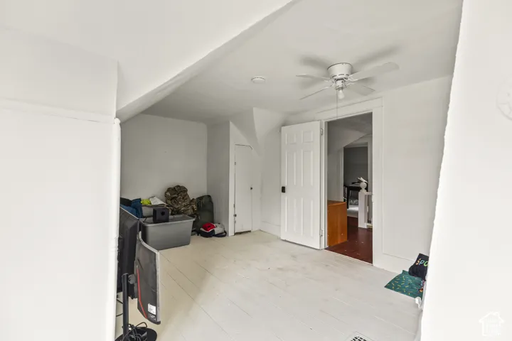 White-painted wood-finish flooring with an angled ceiling
