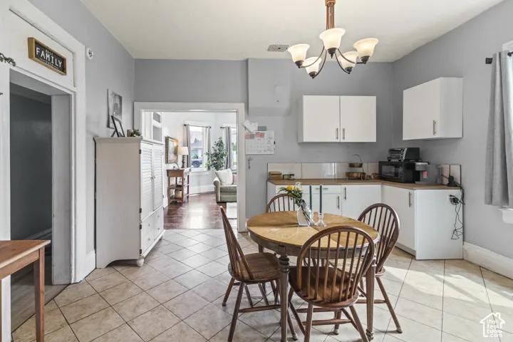 Kitchen with tile flooring, white cabinetry, light countertops, and a ceiling-mounted light fixture