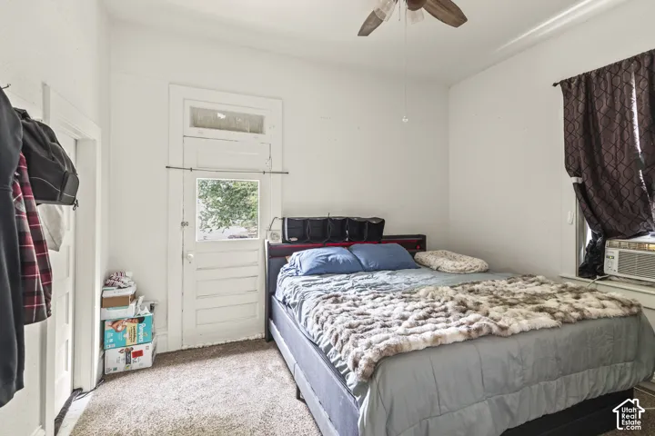 Carpeted flooring with white walls and a ceiling fan