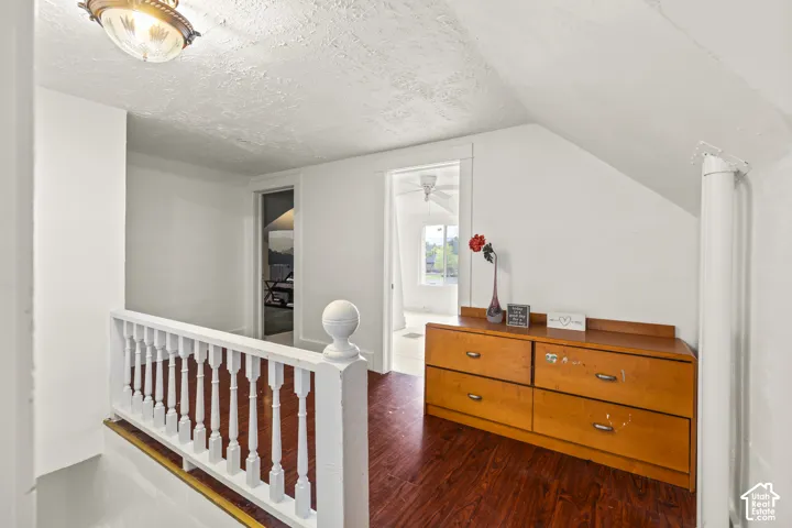 Wood-finish flooring throughout, white painted walls, and a classic white painted balustrade