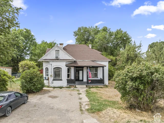 White exterior with dark trim and a covered front porch