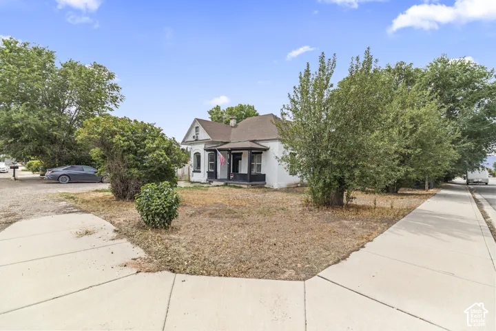 White exterior with dark trim and a covered porch