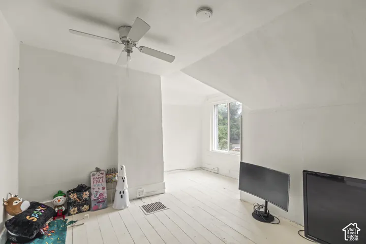 White painted wood-finish flooring with an angled ceiling