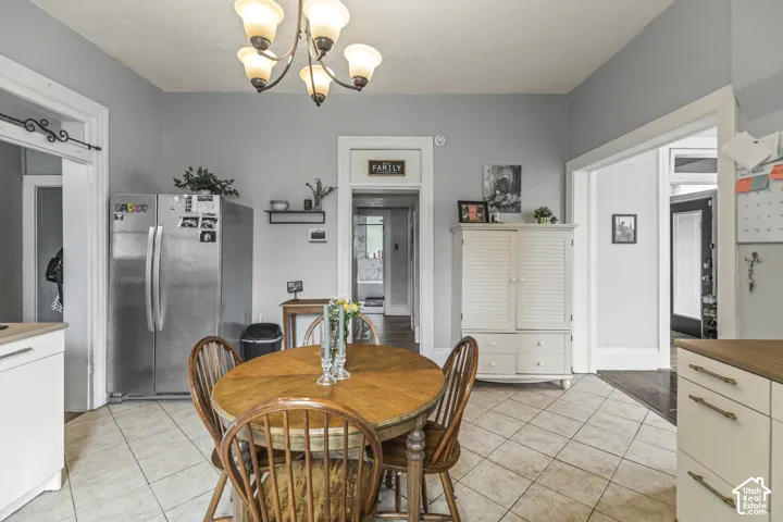 Recessed lighting, ceiling-mounted chandelier, tile flooring, white cabinetry, wood-finish countertops