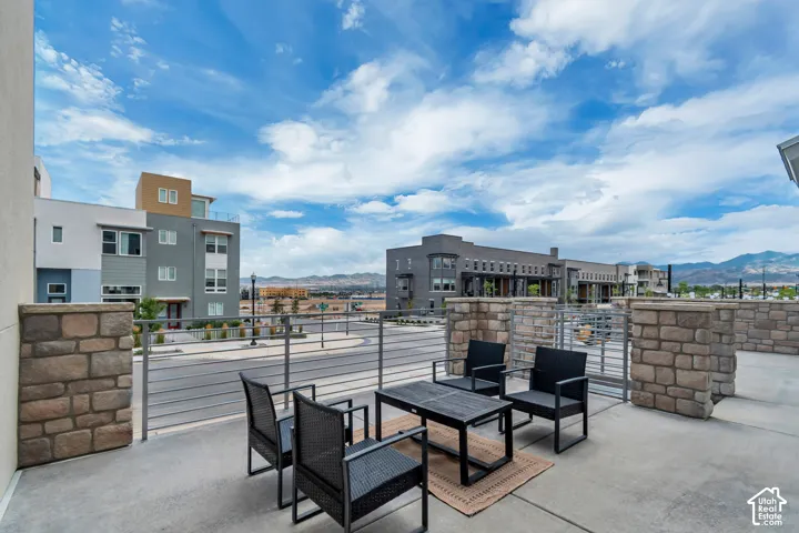 Paved outdoor patio featuring stone-clad walls and metal railing